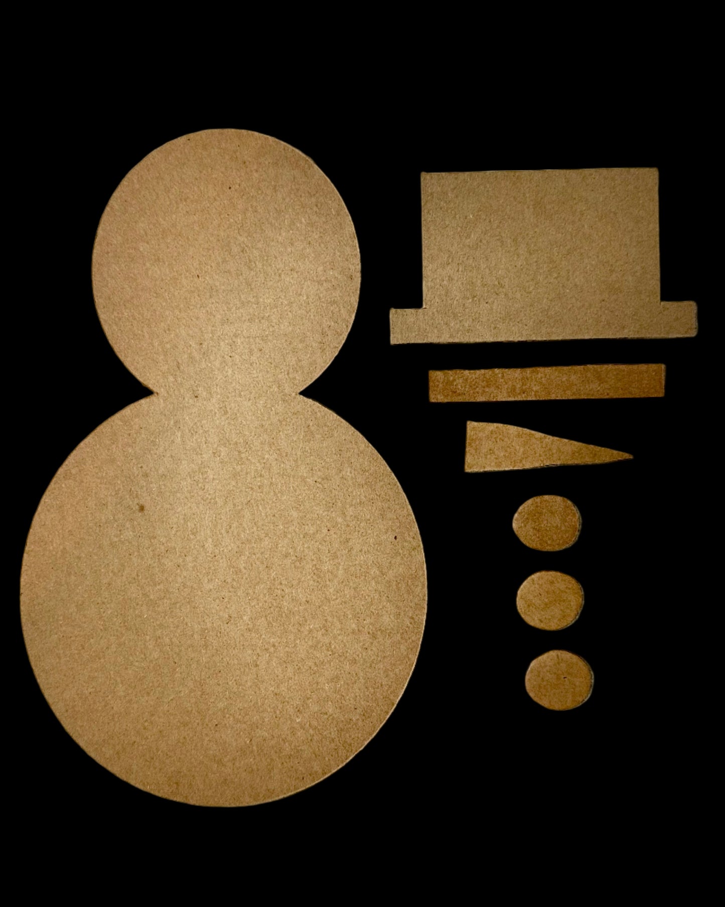 Cardboard cutouts pieces of a Happy Snowman craft kit laid out